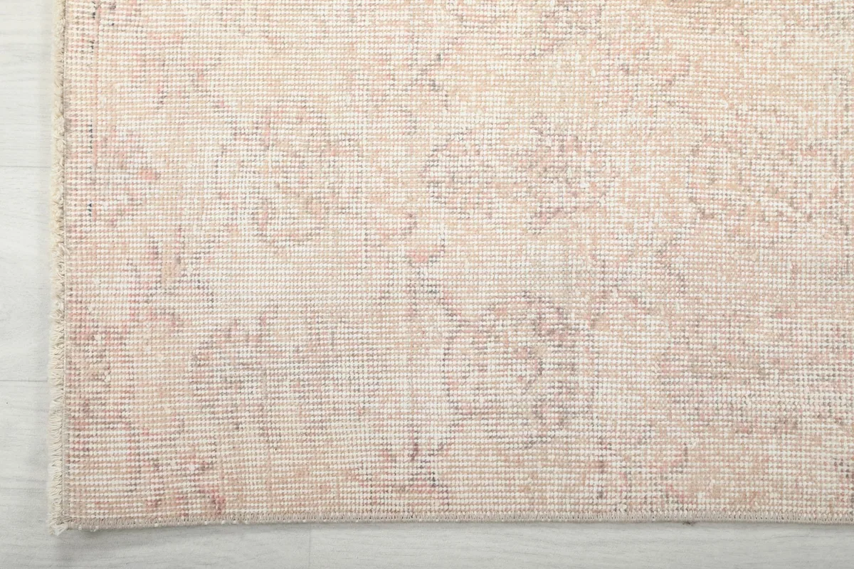 Detail of the rug's edge and border, revealing the tight weave and subtle color shifts.