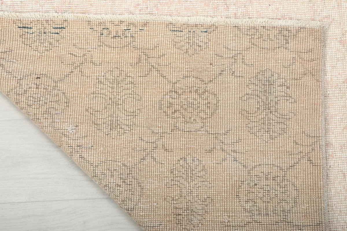 Close-up of the rug's backside, showing the intricate knotting on the cotton foundation.