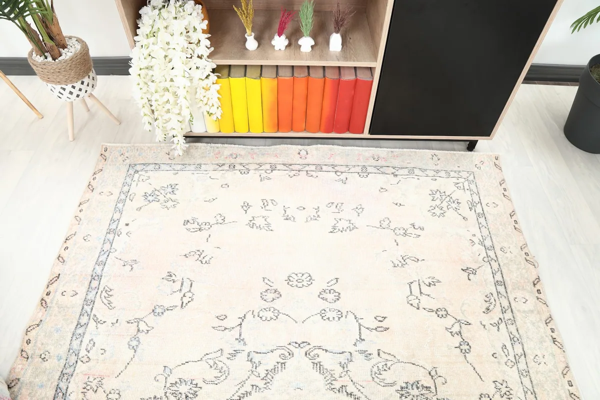 Overhead angle showing the top portion of the ivory rug with its charcoal floral motifs.