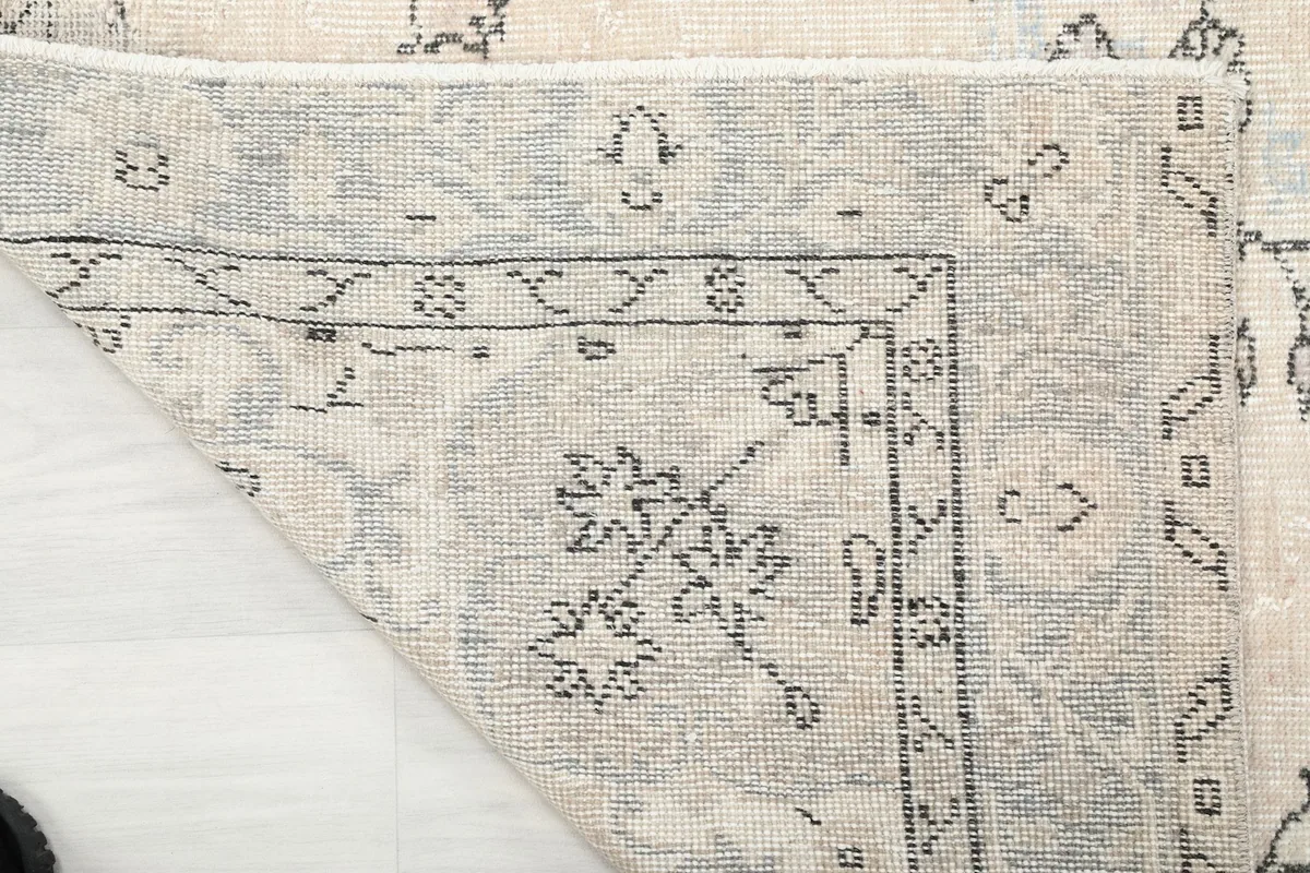 Close-up of the back of the hand-knotted rug, revealing the tight knotting and wool fibers.