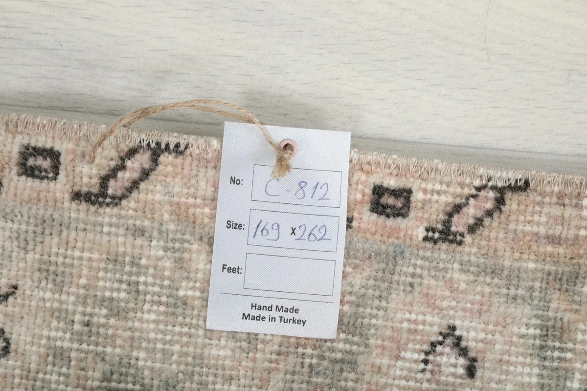Tag showing the rug's dimensions in centimeters (169 x 262) and origin: Made in Turkey.