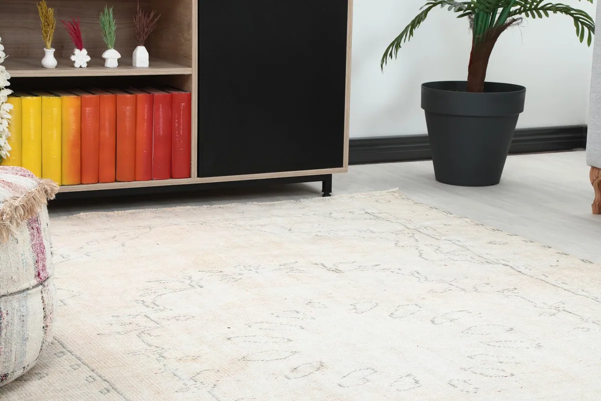 Close-up view of the rug's subtle gray geometric patterns and ivory field next to a cabinet.