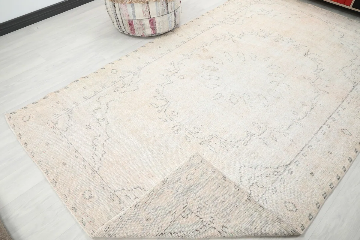 Corner of the rug folded back to show the pile and the reverse side of the hand-knotted structure.