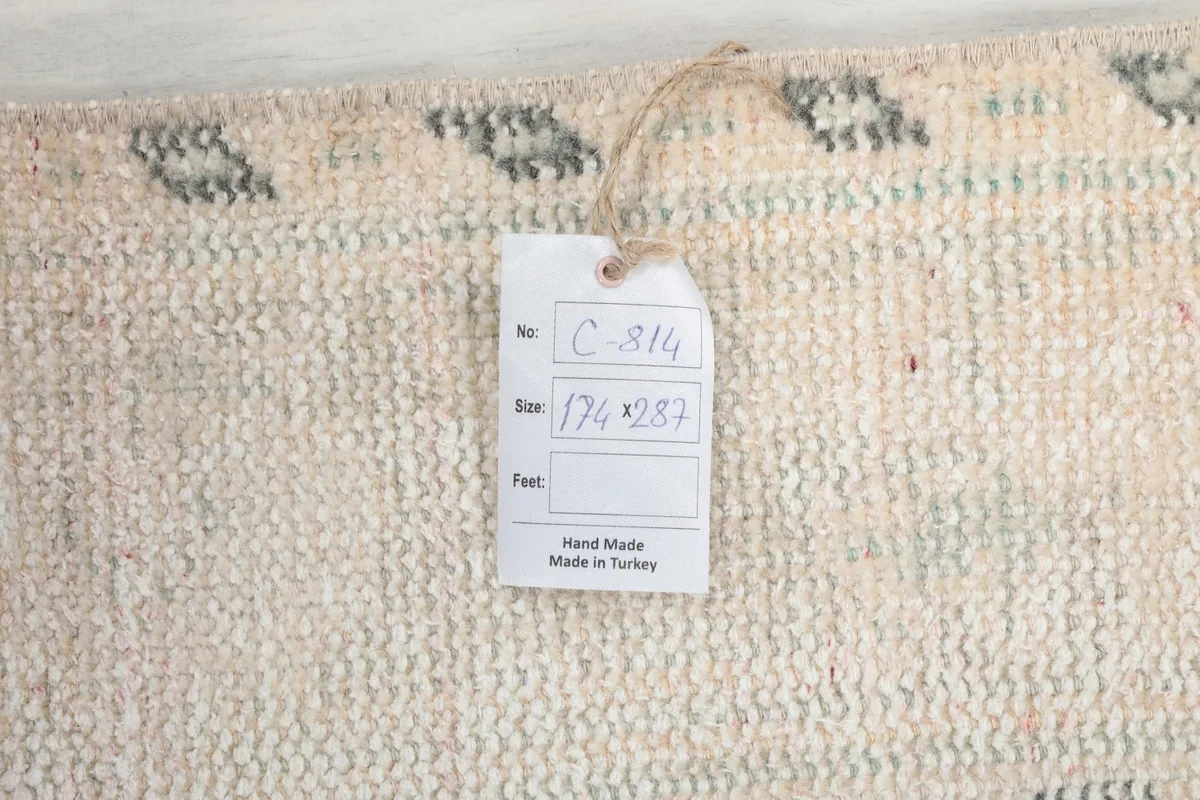 Close-up of the rug's back with a tag showing 'Hand Made in Turkey' and rug dimensions.