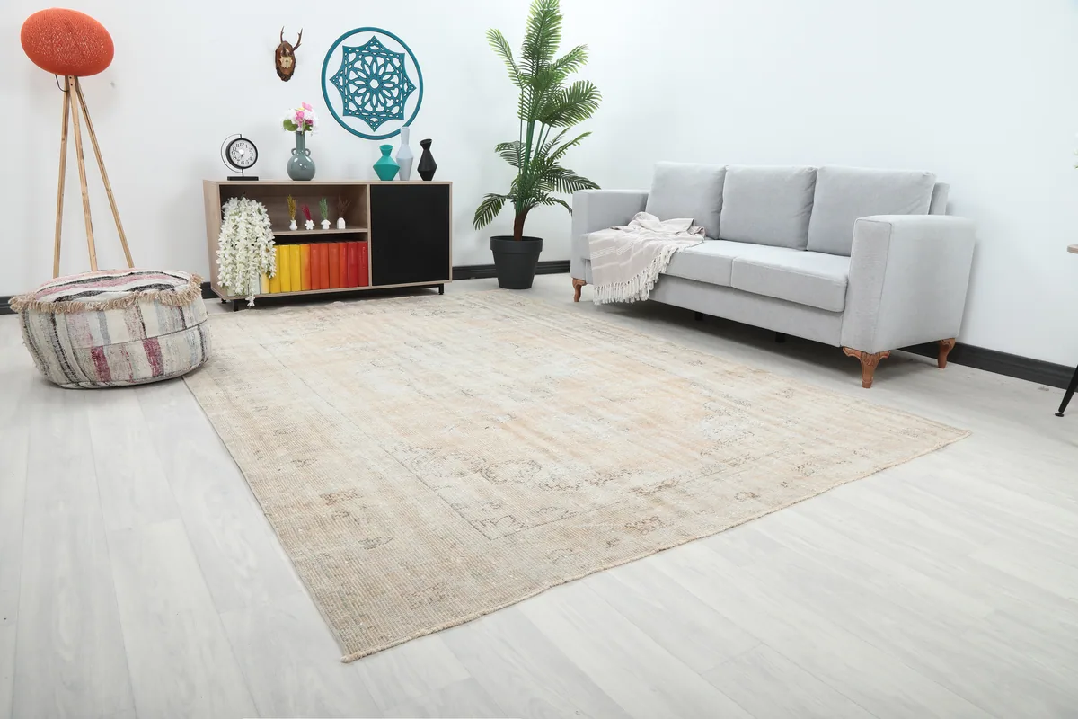 Angle view of the Beige Medallion Oushak Rug in a room, showing its full size and subtle colors.