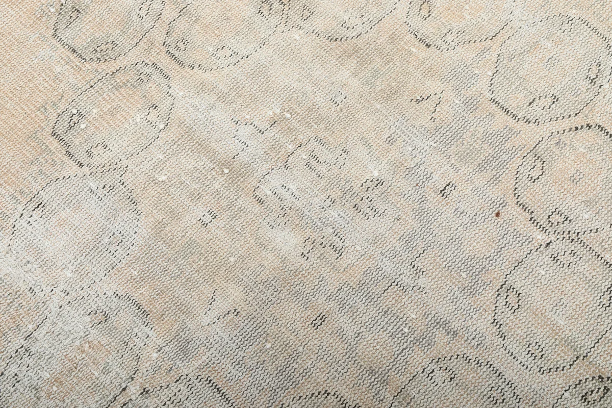 Texture detail of the low wool pile, showing the hand-knotted construction and distressed look.