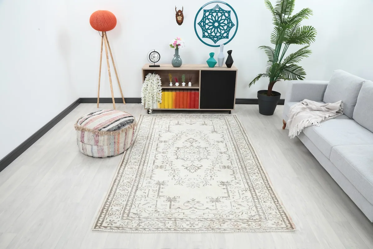 Ivory and beige vintage rug in a modern living room setting with a gray sofa