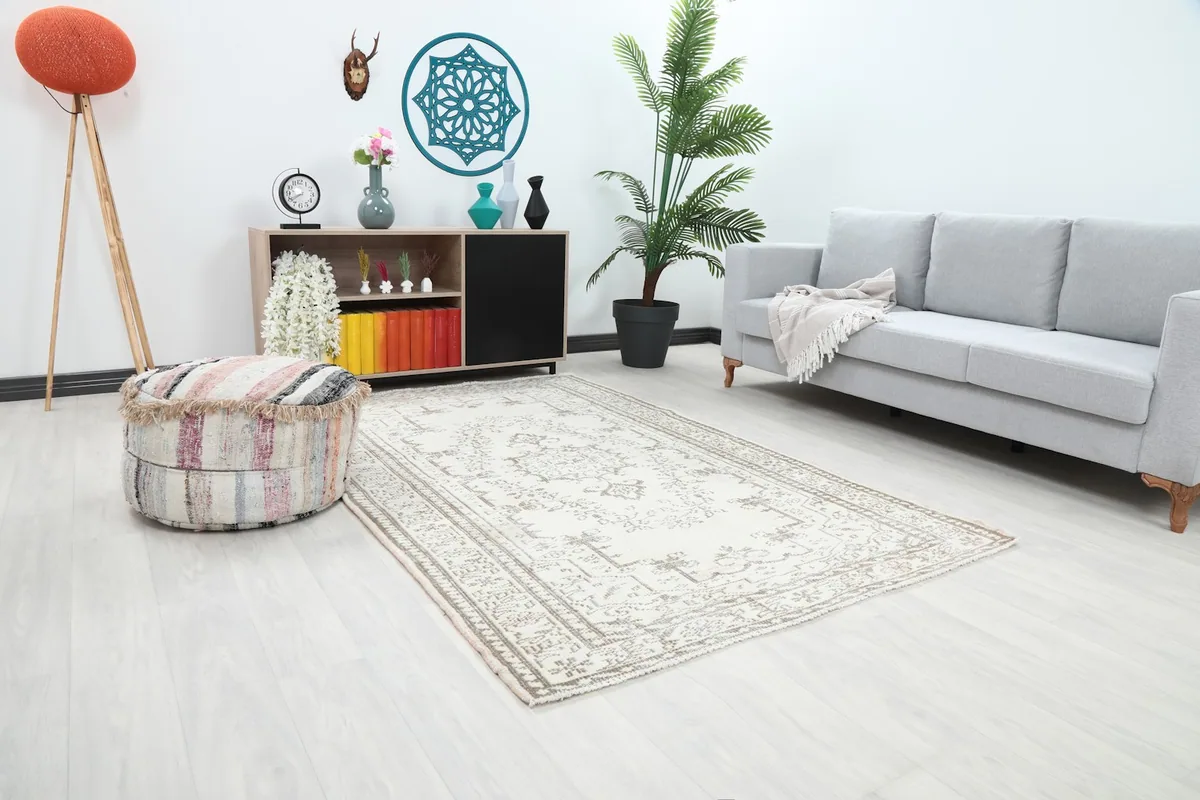 Angle view of the ivory and beige vintage rug in a living room, showing its placement