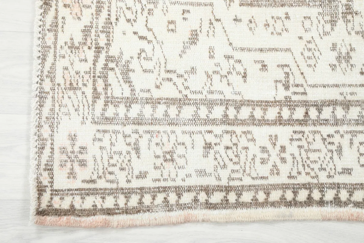 Close-up of the rug's border design and the edge with subtle fringe