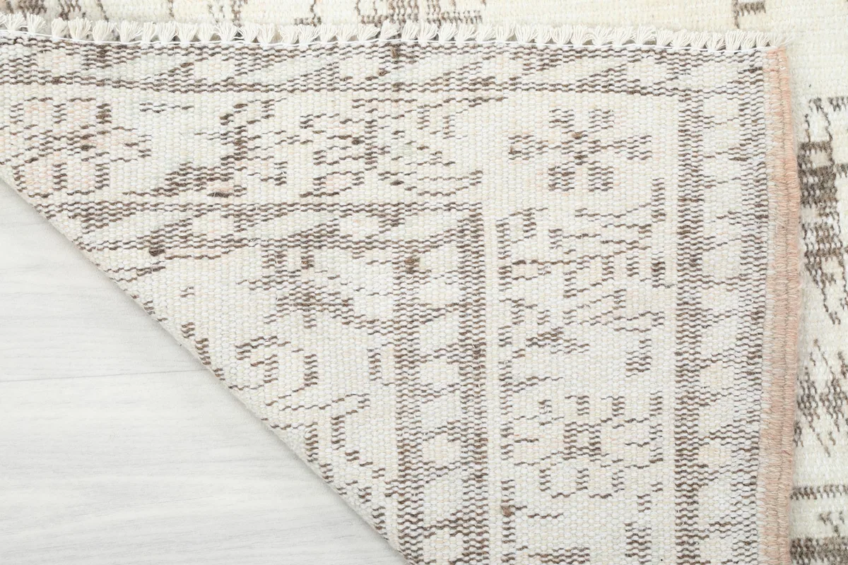Underside view of the hand-knotted cotton foundation and wool pile of the rug