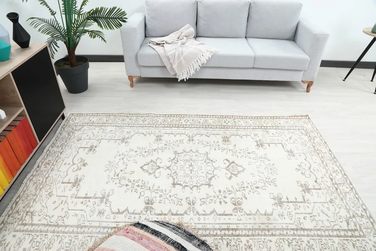 Overhead view of the ivory and beige vintage rug in a room, highlighting the medallion