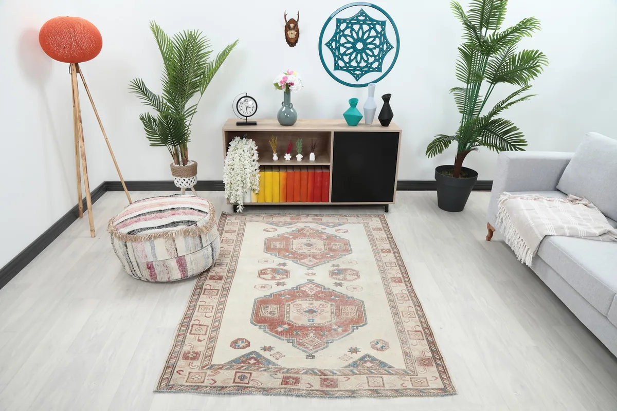 Ivory rust geometric vintage rug styled in a living room with a gray sofa and wooden cabinet