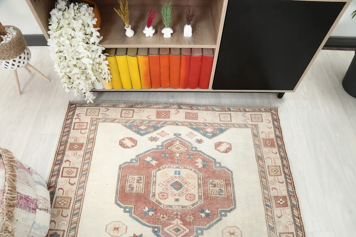 Detail view of the central rust medallion and ivory field of the vintage rug