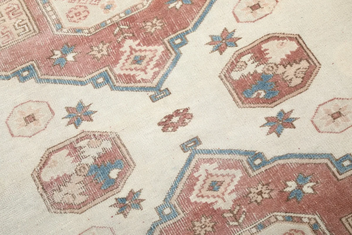 Detailed view of the central motifs and blue accents within the rust medallions