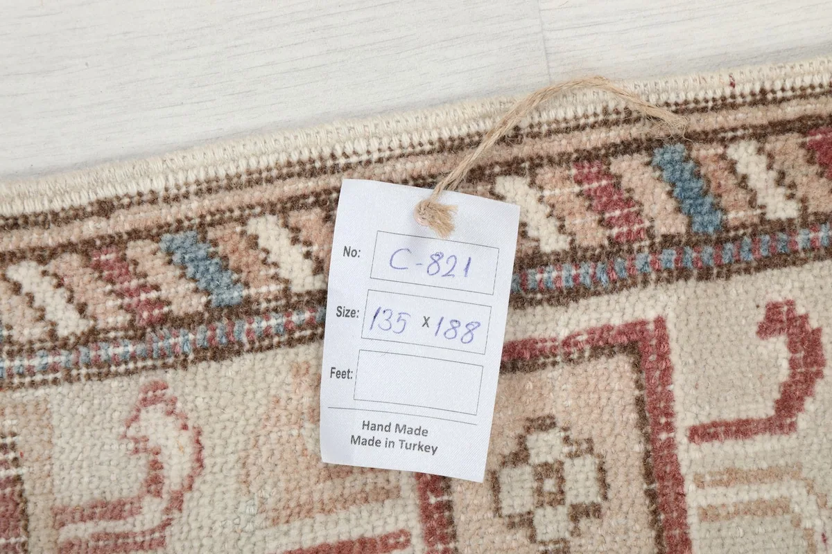Close-up of the rug's label showing the dimensions 135 x 188 cm and 'Hand Made in Turkey'