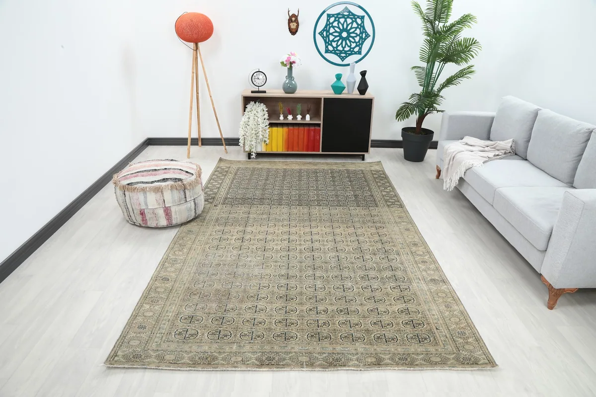 Vintage Anatolian rug in a modern living room setting, showcasing its full size and pattern from an angle.