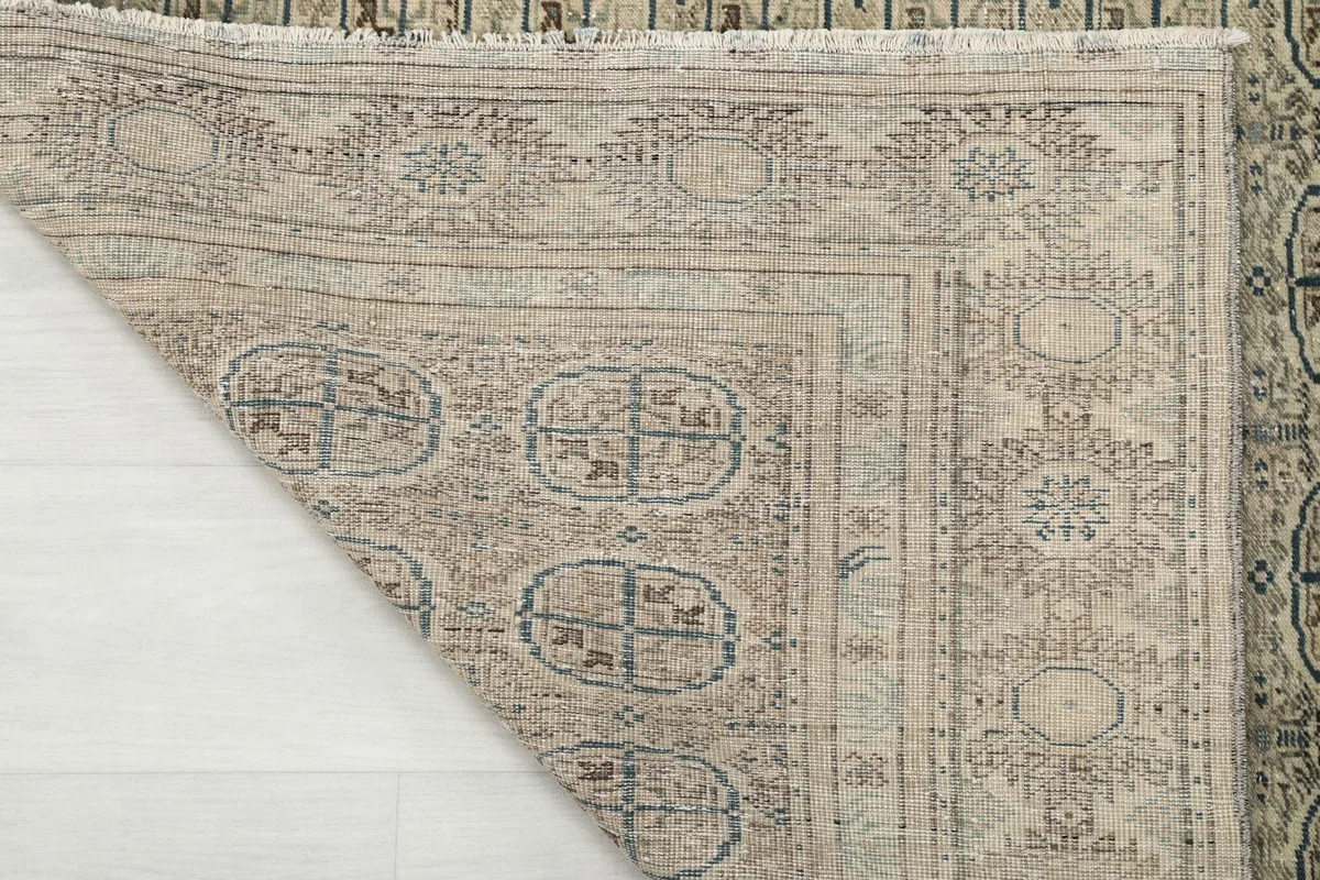 Close-up of the rug's reverse side, showing the knotting structure and the cotton foundation.