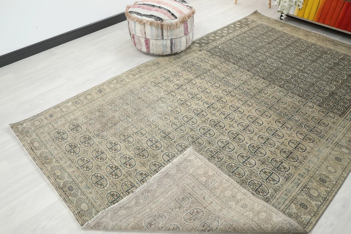 Rug with a corner folded back, revealing the reverse side and the visible texture of the wool pile.