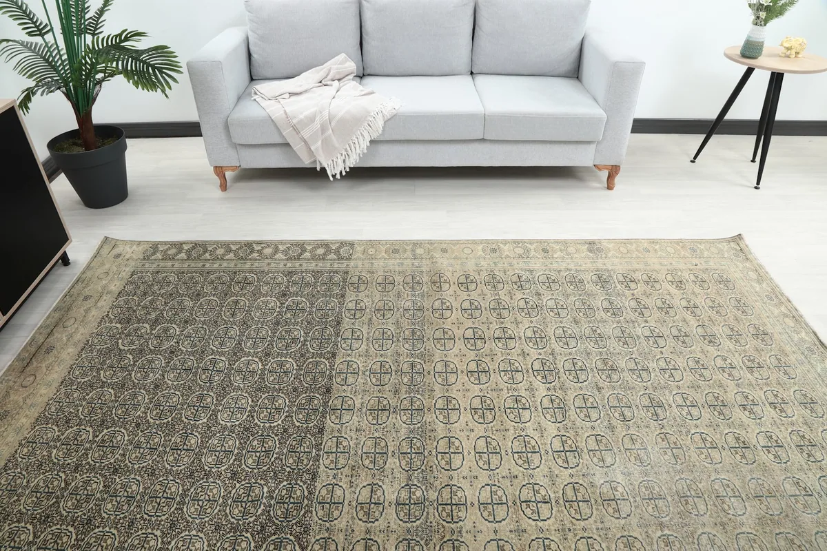Overhead view of the rug laid out in a room, highlighting the central geometric design and color variation.