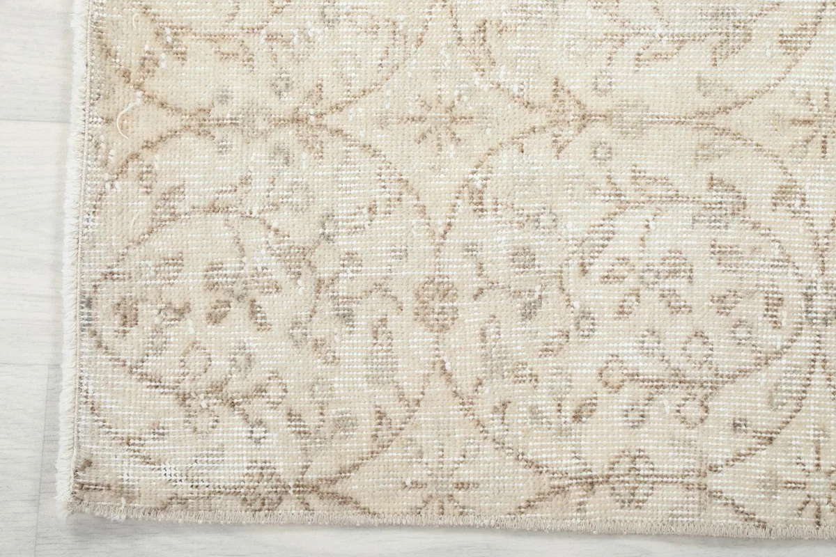 Corner detail showing the subtle border design and fringe of the ivory Anatolian rug