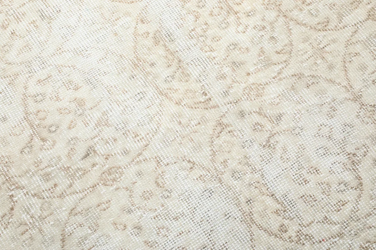 Close-up of the low pile and intricate hand-knotted wool texture of the vintage rug