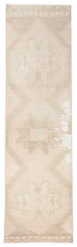 Full top view of the beige and rose vintage Anatolian runner rug on a white background.