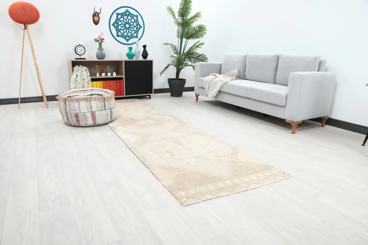 Angle view of the runner rug in a room, showing its length and placement next to a sofa.