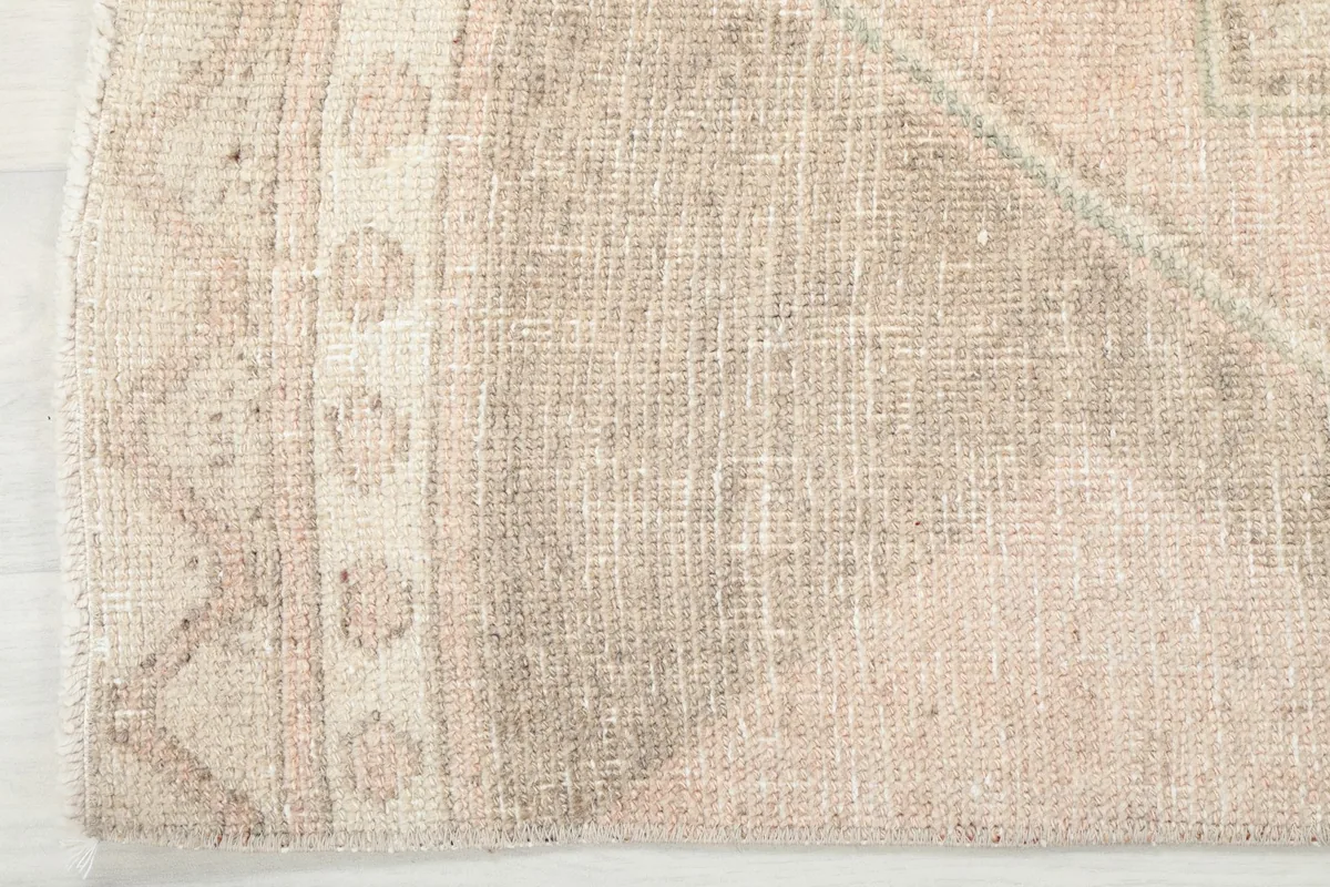 Close-up of the rug's border design, showcasing the intricate patterns and wool texture.