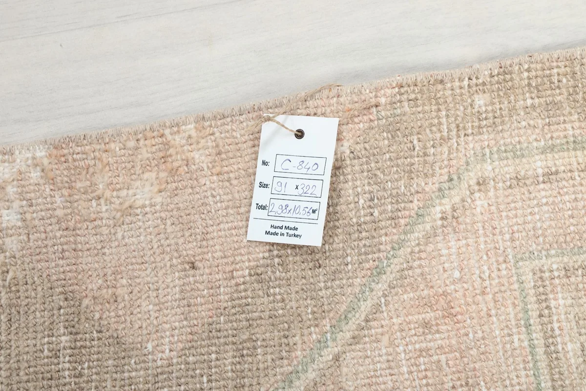 Detail showing the product tag attached to the rug, indicating its origin and dimensions.
