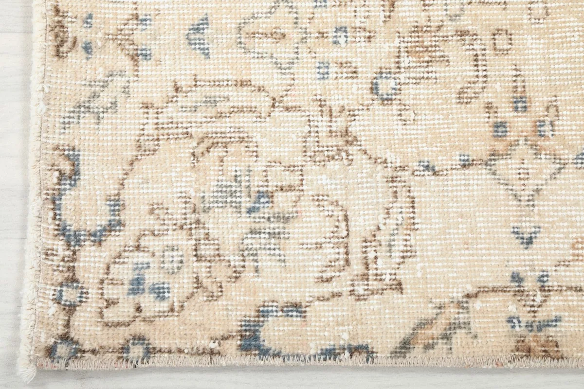 Detail of the rug's subtle border design and corner wear