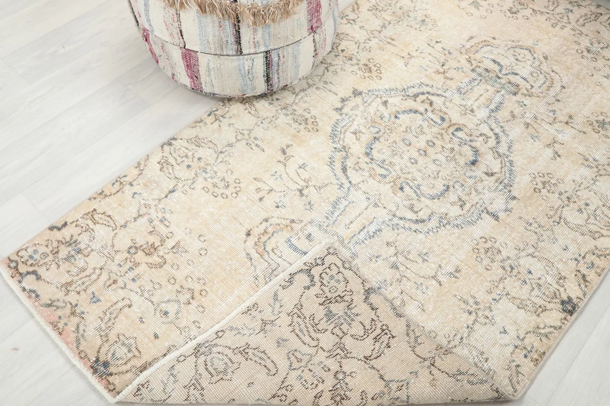 Corner of the rug folded back to show the hand-knotted construction