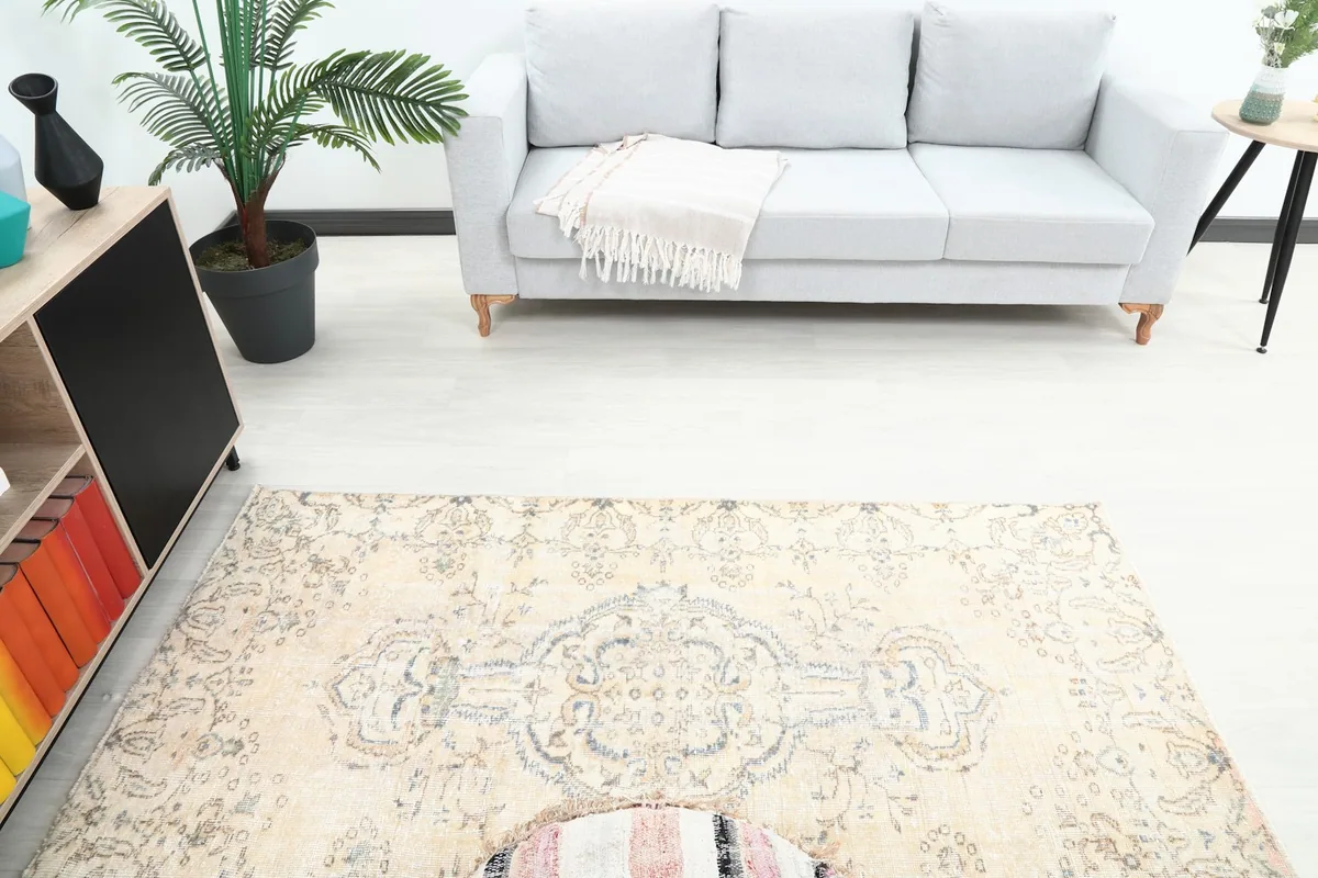 Overhead view showing the rug's placement relative to a sofa and cabinet