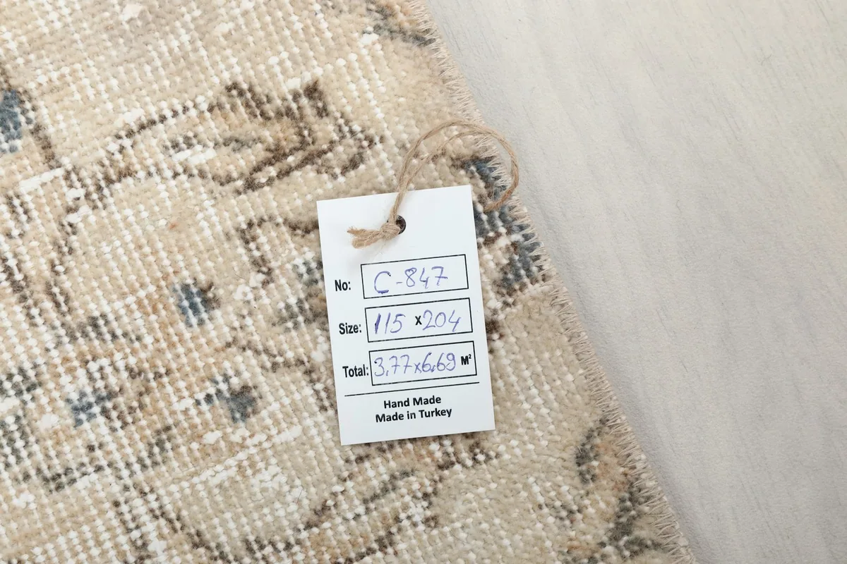 Product tag displaying rug dimensions and origin, placed on the rug