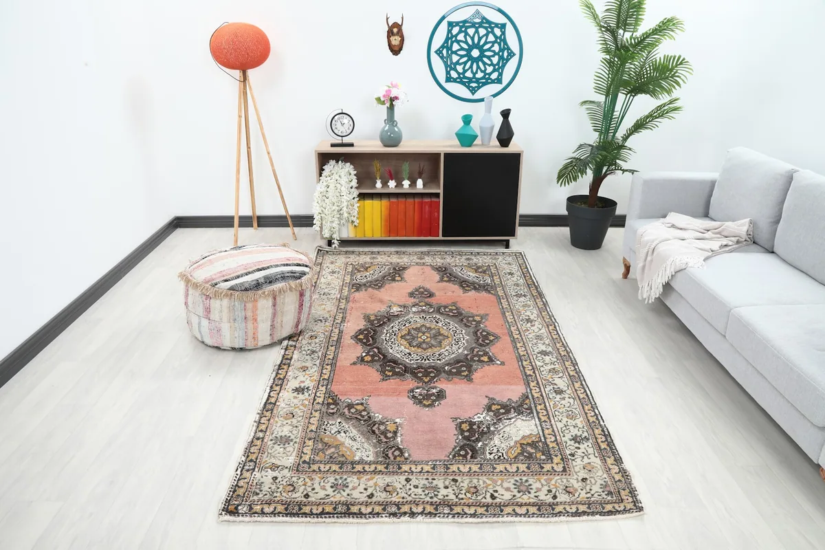 Full room view of the vintage rug in a living space with a gray sofa and wooden furniture.