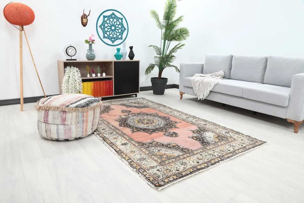 Angle view of the rose and ivory rug in a room setting, showing its placement with home decor.