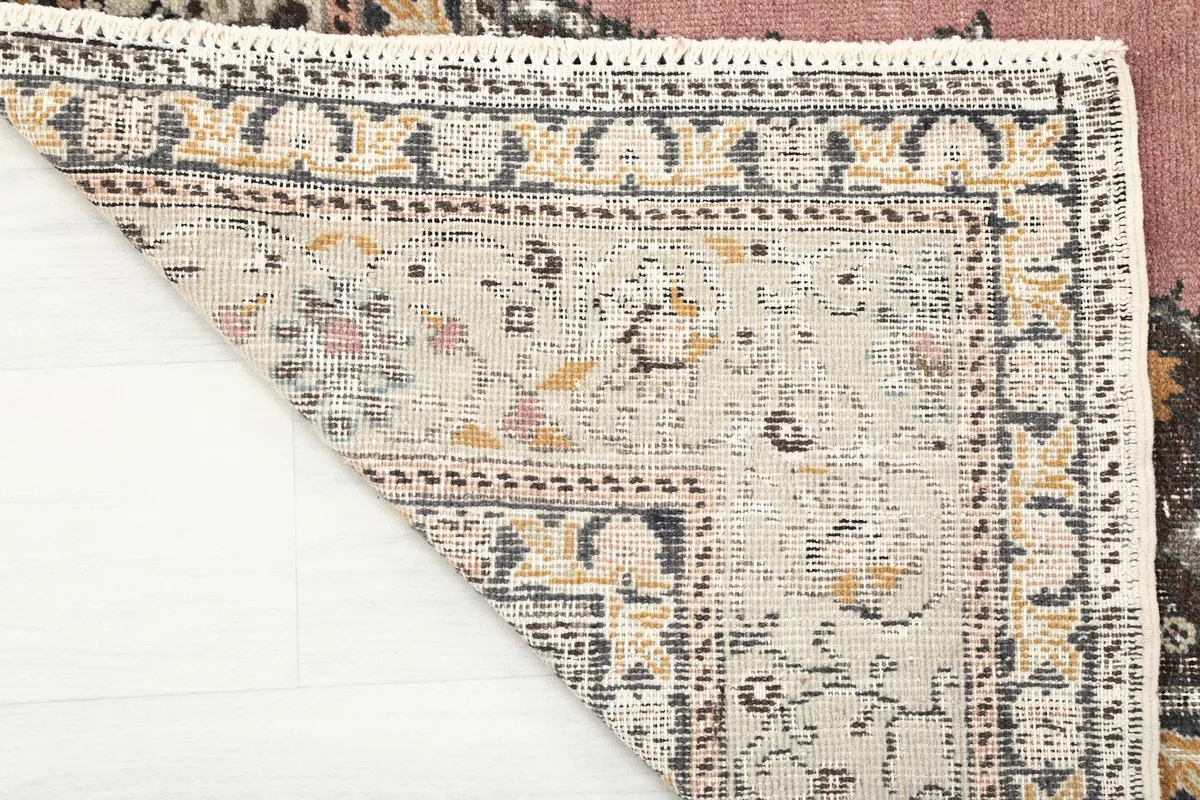 Close-up of the back of the rug, revealing the hand-knotted cotton foundation and wool knots.
