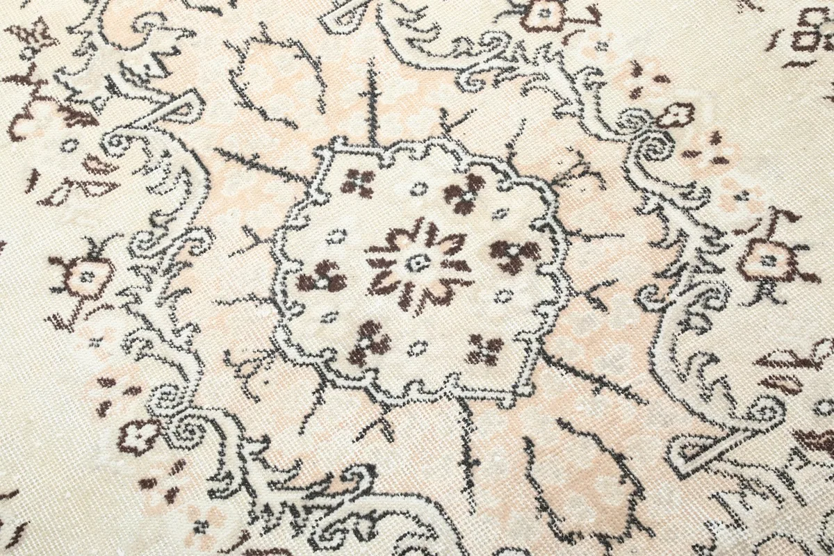 Close-up of the central medallion and surrounding floral patterns, showing the hand-knotted detail and low pile