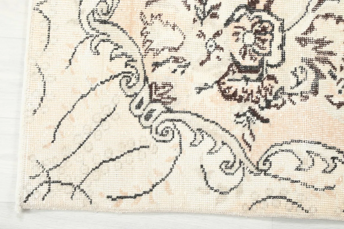 Detailed shot of the rug's outer border and corner, revealing the intricate scrollwork and edge finishing