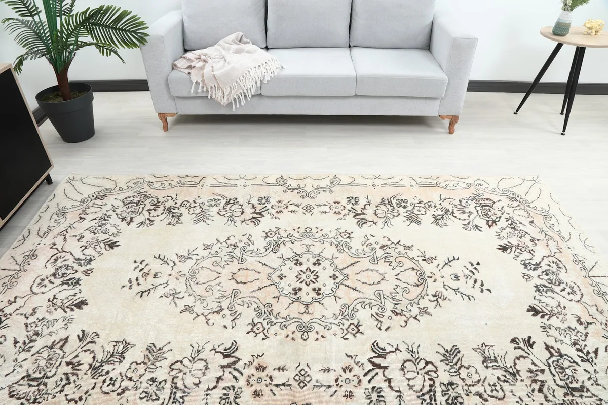 Overhead view of the cream rug in a room, focusing on the central medallion and surrounding floral motifs