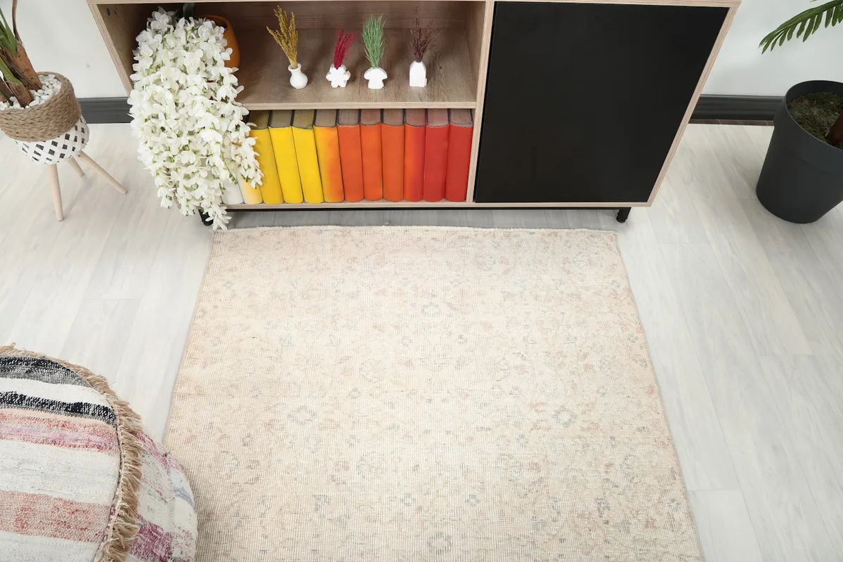 Direct overhead shot of the ivory area rug, highlighting its full pattern and color variations.