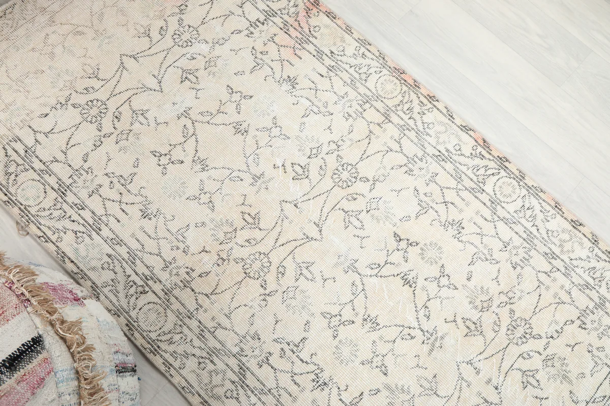 Faded Ivory Floral Anatolian Rug with a close-up view of the charcoal floral motifs and ivory field