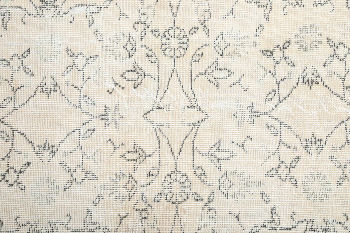 Detailed view of the Faded Ivory Floral Anatolian Rug's central floral and geometric patterns