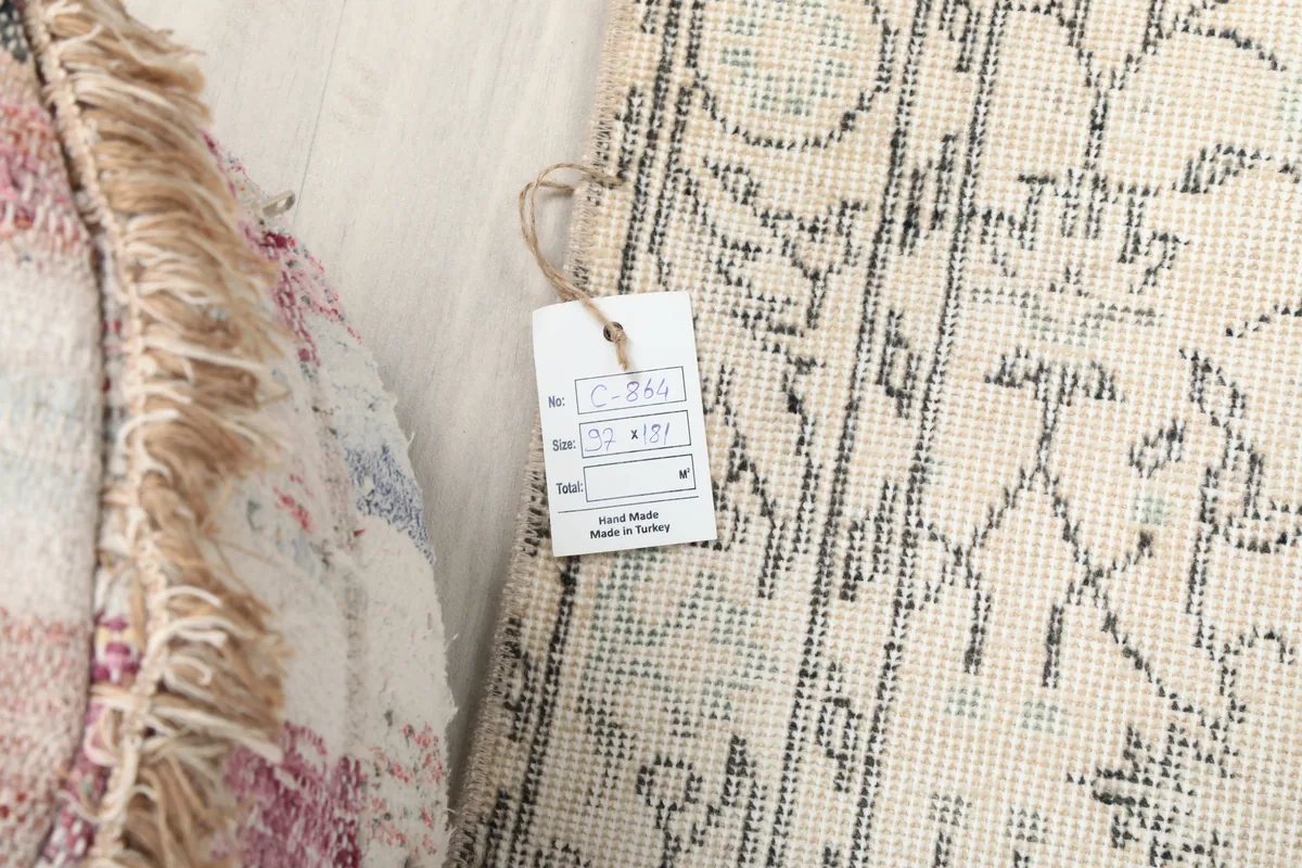 Faded Ivory Floral Anatolian Rug with its product tag, displaying size and origin details