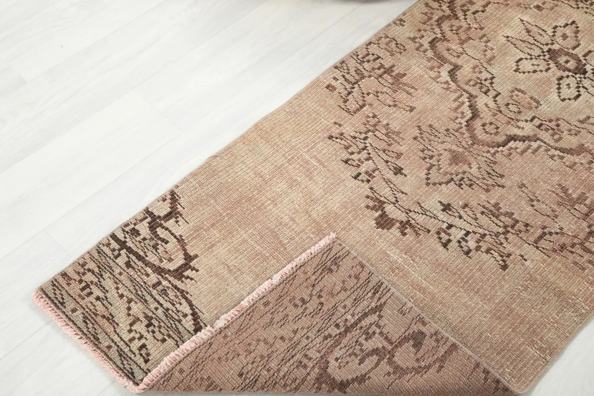 View of the runner rug folded back, showing the back of the rug and the quality of the hand-knotting.