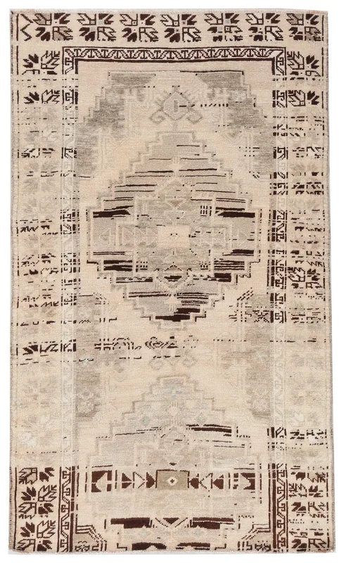 Full overhead view of the beige and charcoal geometric Anatolian vintage rug on a white background