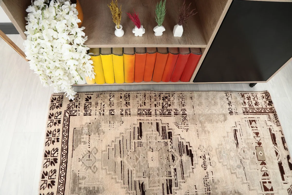 Angled top view of the vintage rug, highlighting its central design and colors against the floor