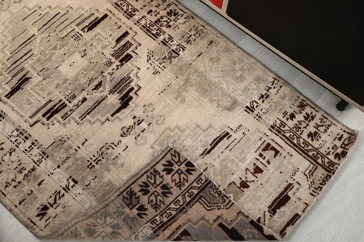 Corner of the rug folded back to reveal the cotton foundation and the reverse side of the hand-knotting