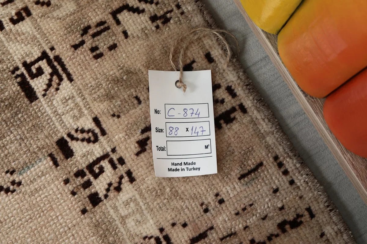 Product tag showing the rug's dimensions (88 x 147 cm) and 'Hand Made Made in Turkey'