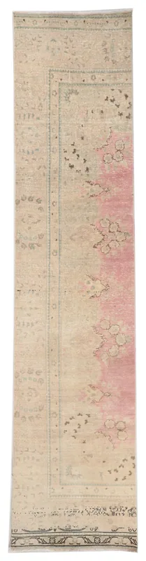 Full top view of the 2'9" x 12'4" vintage Anatolian runner rug with pink floral motifs on a beige field.