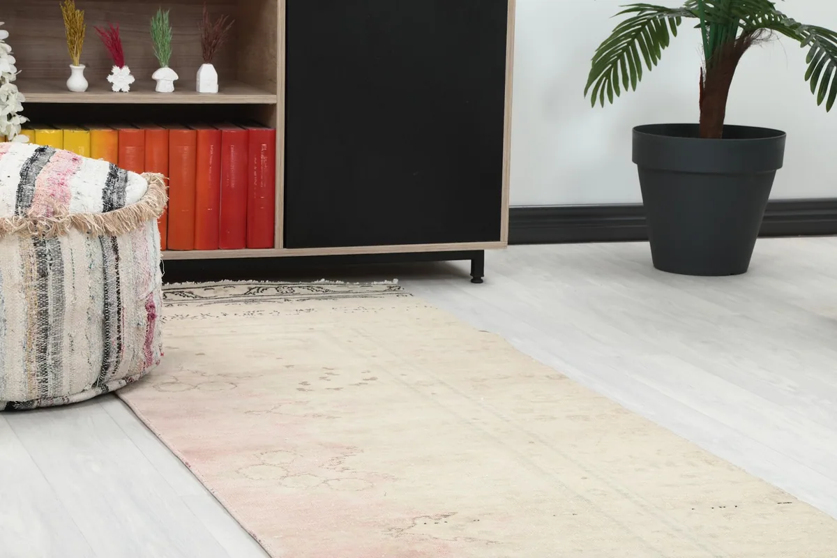 Close-up angle view of the runner rug's texture and colors near a piece of furniture.
